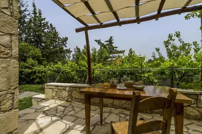 a wooden table and chairs on a patio at Manoli's House in Douliana