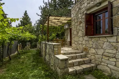 a stone house with a stone wall and a window at Manoli's House in Douliana