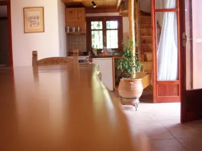 a living room with a wooden floor and a kitchen at Manoli's House in Douliana