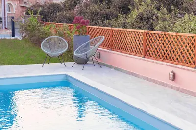 two chairs sitting next to a swimming pool at Cellar - Shared Pool & Nature Views in Spiliá