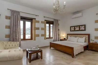 a large bedroom with a bed and a couch at Villa Chrysseva in Plátanos