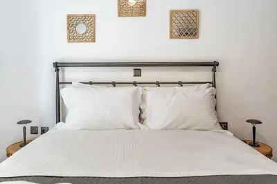 a bedroom with a bed with white sheets and pillows at REN Apartment in Stalos