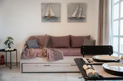 a living room with a couch and two sailboats on the wall at REN Apartment in Stalos