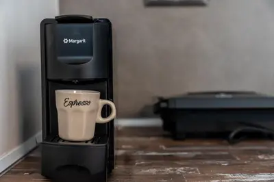 a coffeemaker with a coffee cup on a table at REN Apartment in Stalos
