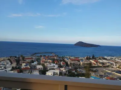 a view of a city and the ocean from a balcony at Meteoron Platanias in Plataniás