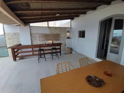 a living room with a wooden table and chairs at Meteoron Platanias in Plataniás