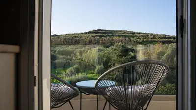two chairs and a table on a balcony with a view at Elaya Experience in Kamisianá