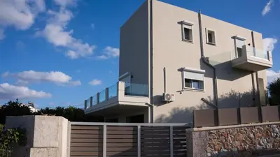 a white building with a fence in front of it at Elaya Experience in Kamisianá