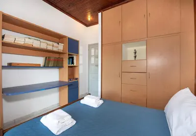 a bedroom with a blue bed and wooden cabinets at Esperado Gardens Maleme in Maleme