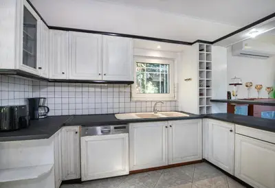 a kitchen with white cabinets and a sink at Esperado Gardens Maleme in Maleme