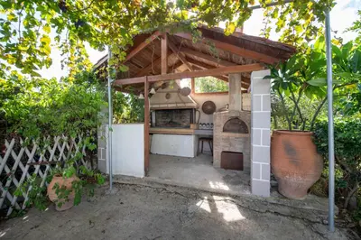 a outdoor kitchen with a pizza oven in a backyard at Esperado Gardens Maleme in Maleme