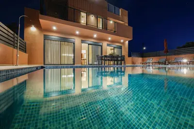 a swimming pool in front of a building at night at Madre Tierra Boutique Villas 3 & 4 in Potistíria
