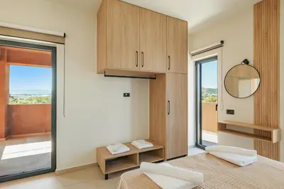 a bedroom with two beds and a mirror and a window at Madre Tierra Boutique Villas 3 & 4 in Potistíria
