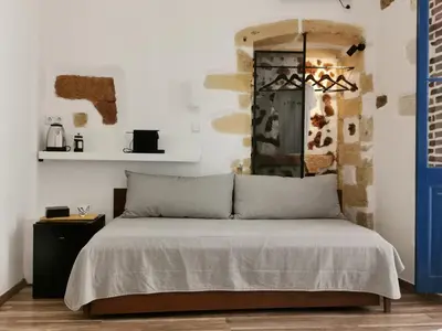 a bedroom with a bed with a blue door at casa di pietra in Chania Town