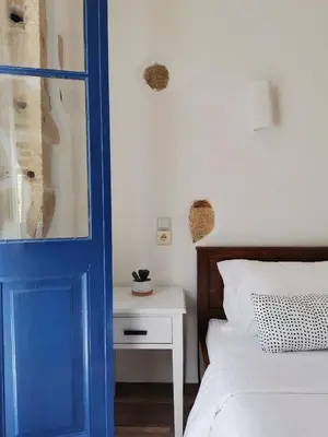 a bedroom with a blue door and a bed and a nightstand at casa di pietra in Chania Town