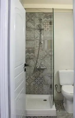 a shower with a glass door in a bathroom at casa di pietra in Chania Town