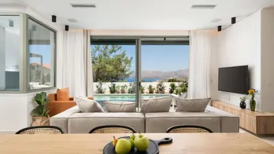 a living room with a couch and a large window at Two Seaview Villas With Elegant Design in Agios Onoufrios