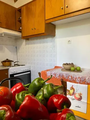 a kitchen with a table full of tomatoes and peppers at Alkis Olive Grove Cottage in Vasilópoulon