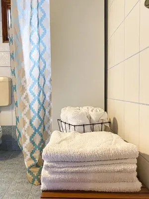 a pile of towels on a rack in a bathroom at Alkis Olive Grove Cottage in Vasilópoulon
