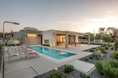 a backyard with a swimming pool and a house at Deux Olives Luxury Villa in Maleme