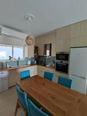 a kitchen with a wooden table and blue chairs at Downtown house with seaview near to the beach in Chania Town