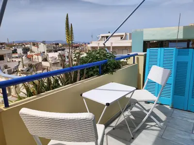 a table and chairs on a balcony with a view at Downtown house with seaview near to the beach in Chania Town