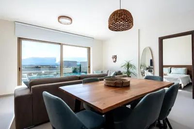 a living room with a wooden table and chairs at Elpida Luxury Villa, private pool, fantastic view! in Stérnai