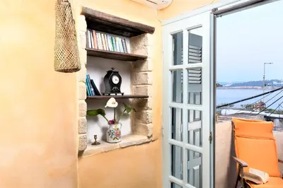 an open door to a balcony with a clock on a shelf at House Minoos in Chania Town