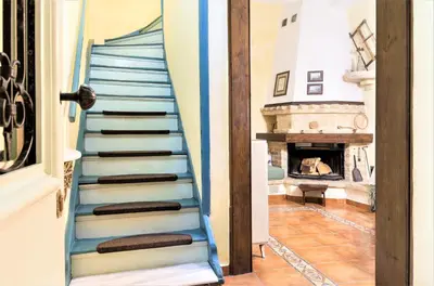 a staircase leading to a living room with a fireplace at House Minoos in Chania Town