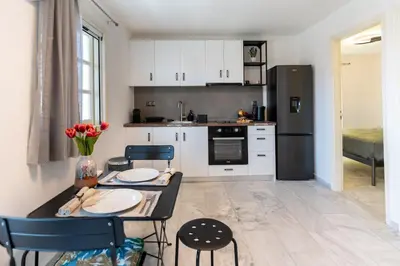 a kitchen with a table and chairs and a black refrigerator at SeaREN Apartment in Stalos