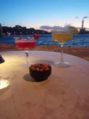three cocktails on a table with a bowl of food at SeaREN Apartment in Stalos