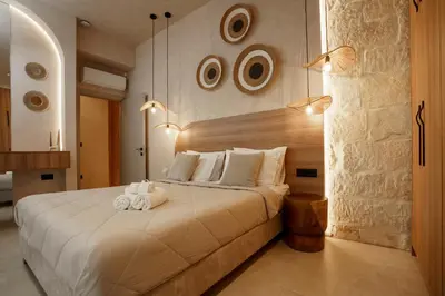 a bedroom with a large white bed with two towels at HOLM Ilex & Quercus apartments in Chania Town
