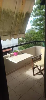 a bench on a balcony with a table and a chair at 1st floor studio in Kalathas in Kalathas