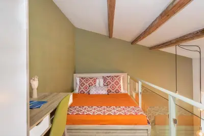 a small bedroom with a bed with an orange bedspread at Rea Studio 2 in Chania Town
