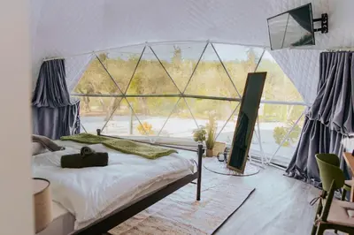 a bedroom with a bed and a large window at Olive Dome, Luxury Glamping Dome in Crete in Gavalochori