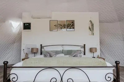 a bedroom with a bed with two people on it at Olive Dome, Luxury Glamping Dome in Crete in Gavalochori