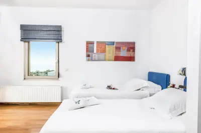 two beds in a room with white walls at Villa Mariposa - panoramic sea view - near Chania city in Chania Town