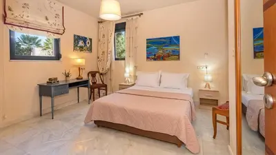 a bedroom with a bed and a desk in it at Lithos Serenity in Argoulidhés