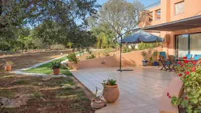 a patio with an umbrella and a table and chairs at Lithos Serenity in Argoulidhés