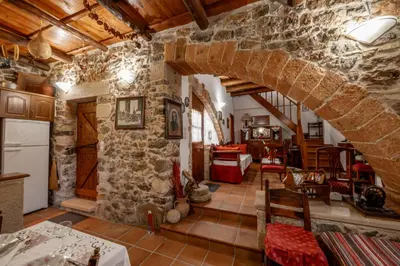 a kitchen and living room with a stone wall at Agapi's Charming Retreat - Rustic Escape in Chania in Maláxa