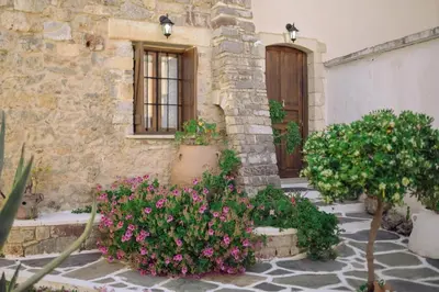a stone building with flowers in front of a door at Agapi's Charming Retreat - Rustic Escape in Chania in Maláxa