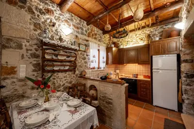 a kitchen with a table with plates and a refrigerator at Agapi's Charming Retreat - Rustic Escape in Chania in Maláxa
