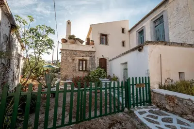 a green fence in front of a house at Agapi's Charming Retreat - Rustic Escape in Chania in Maláxa