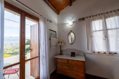 a bedroom with a dresser and a large window at Agapi's Charming Retreat - Rustic Escape in Chania in Maláxa