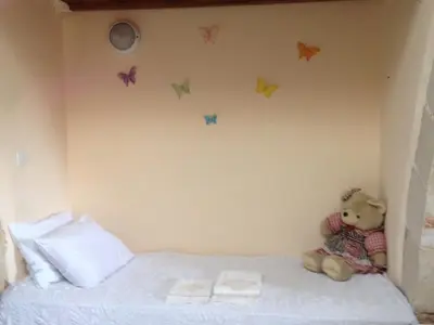 a teddy bear sitting on a bed with butterflies on the wall at Casa Antica
