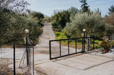 a gate leading down a dirt road with trees at Lemon Dome, Luxury Glamping Dome in Crete in Gavalochori
