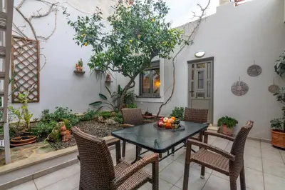 a patio with a table and chairs with fruit on it at Garden house by Dreams in Chania Town