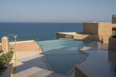 a swimming pool with the ocean in the background at Ocean Bay Sea View Apartment, Pool, Brand New, 2B in Kalyves