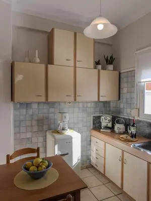 a kitchen with a bowl of fruit on a table at Sunny Nest, Stylish & Bright Urban Retreat in Chania Town