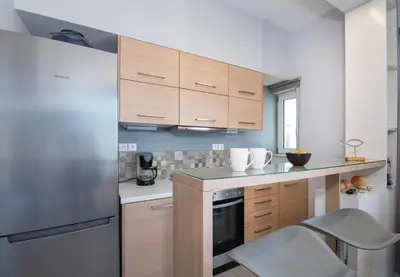 a kitchen with wooden cabinets and a stainless steel refrigerator at Stelios Florans Apartment in Chania Town
